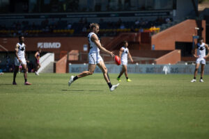 Southports Sam Day kicks for goal against Brisbane.