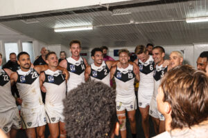 Southport Sharks sing their song in the rooms at North Hobart Oval.
